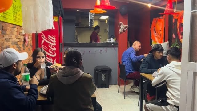Clientes comiendo en el local de Colombian Pizza